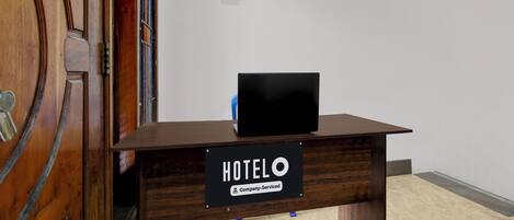 A hotel reception desk with a sign indicating it is company-serviced.