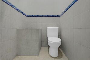 A small, enclosed bathroom with a toilet and a shower stall. - OYO 94935 Rahayu Homestay (Mangunan)