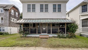 A two-story building with a green metal roof and a front porch. - Steps to Rehoboth Beach: Spacious Family Home! (Rehoboth Beach)