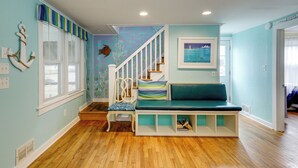 A staircase with a blue wall and a picture of a lighthouse. - Steps to Rehoboth Beach: Spacious Family Home! (Rehoboth Beach)