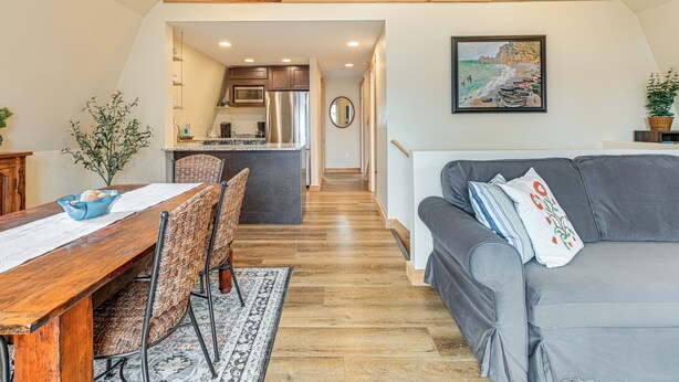 A cozy interior with a dining area, a grey sofa, and a kitchen in the background. - Private Dock & Fire Pit: Beautiful Lake Setting (Bradford)