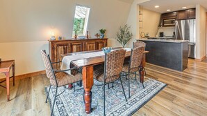 A dining area with a wooden table and chairs, a rug, and a view of the kitchen. - Private Dock & Fire Pit: Beautiful Lake Setting (Bradford)