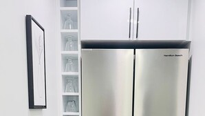 A stainless steel Hamilton Beach refrigerator in a kitchen with white cabinetry and a wooden floor. - Stylish Kinglet Gardens Stay Near Big Lake, Lois Hole Park & West Edmonton Mall (Edmonton)