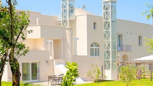Un edificio moderno con tetto piatto, ampie finestre e una torre centrale.
