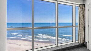 Un amplio ventanal con vista a la playa y al océano.