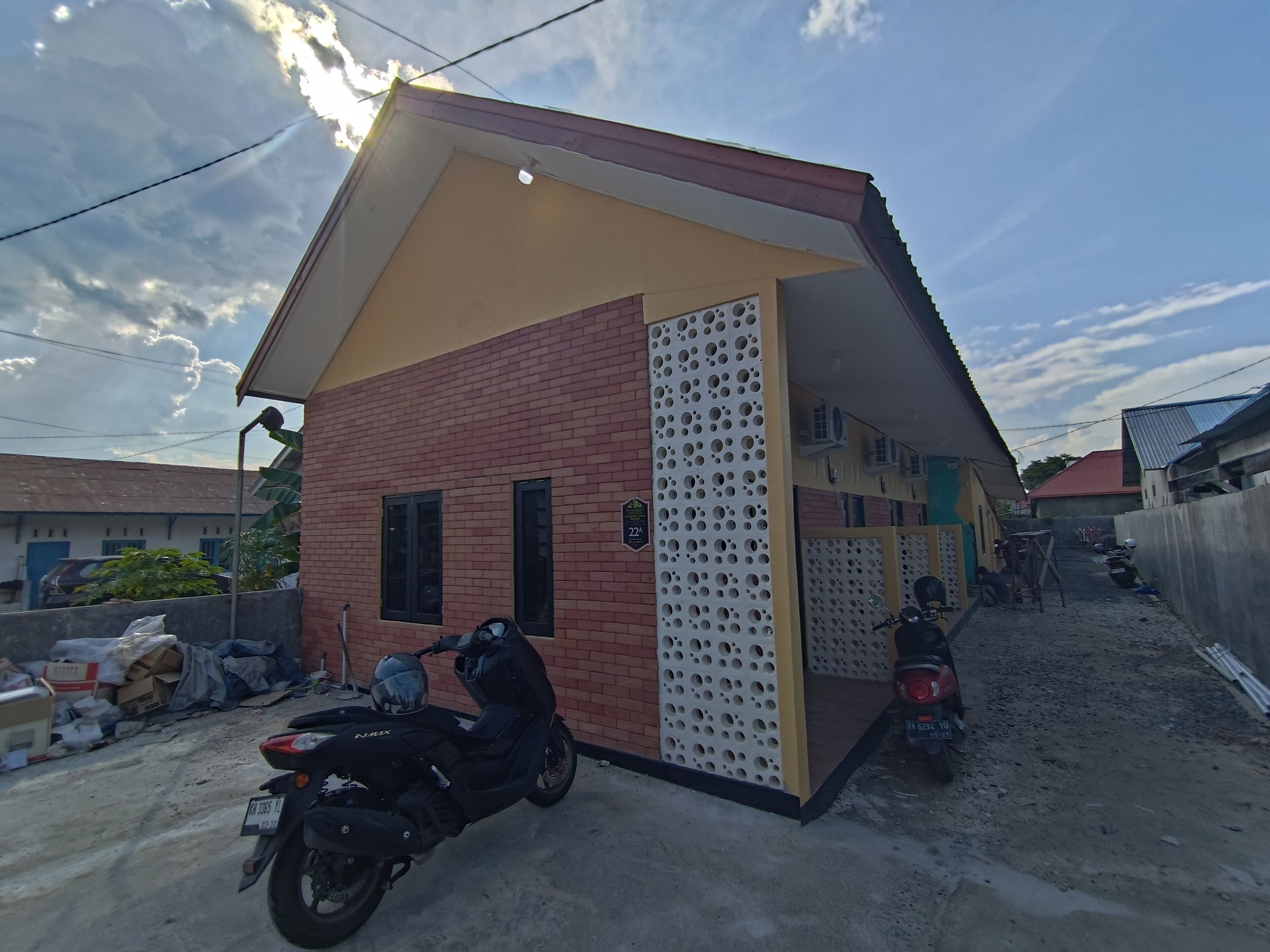Un petit bâtiment doté d’un toit en pente, d’un mur en briques et d’un panneau perforé sur l’un de ses côtés.