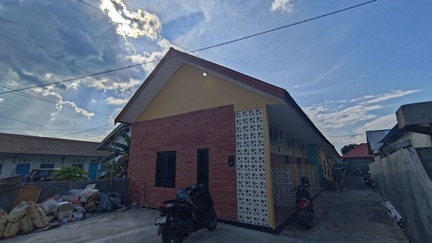 A residential building with a brick facade and a yellow roof. - OYO 94933 Wisma Cha Tatami Palangkaraya (Palangkaraya)