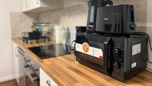 A kitchen with a black coffee maker, a toaster, and a microwave.