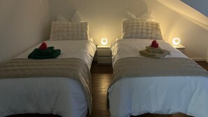 Two twin beds with white bedding and pillows, each with a bedside lamp.