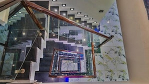 A modern staircase with glass railings and a geometric design. - Hotel Aura Inn (Srinagar)