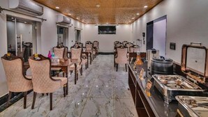 A hotel room with a marble floor, wooden ceiling, and a buffet area with various food items. - Hotel Aura Inn (Srinagar)