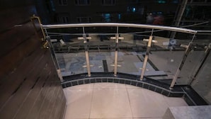 A glass balustrade with metal railings and a tiled floor. - Hotel Aura Inn (Srinagar)
