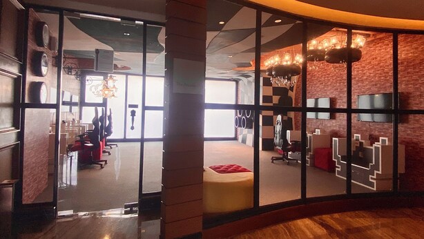 A modern hotel lobby with a curved glass wall, a reception desk, and a chandelier. - Opulent Studio in delightful Makati with fantastic Amenities (Makati)