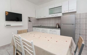 A modern kitchen with white cabinets, a stainless steel refrigerator, and a flat-screen TV mounted on the wall. - Beautiful apartment in Bibinje with WiFi (Bibinje)