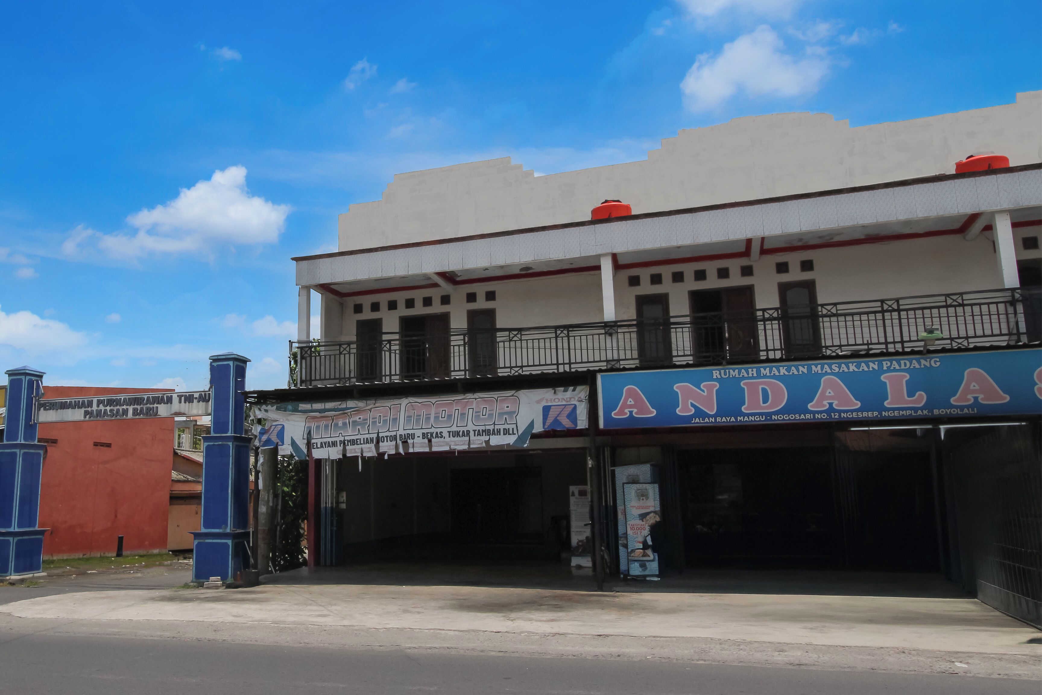 A building with a sign for 'ANDALAS' and another for 'PERILAMAN PUNAWIRAMAN PANASAN BARU'.