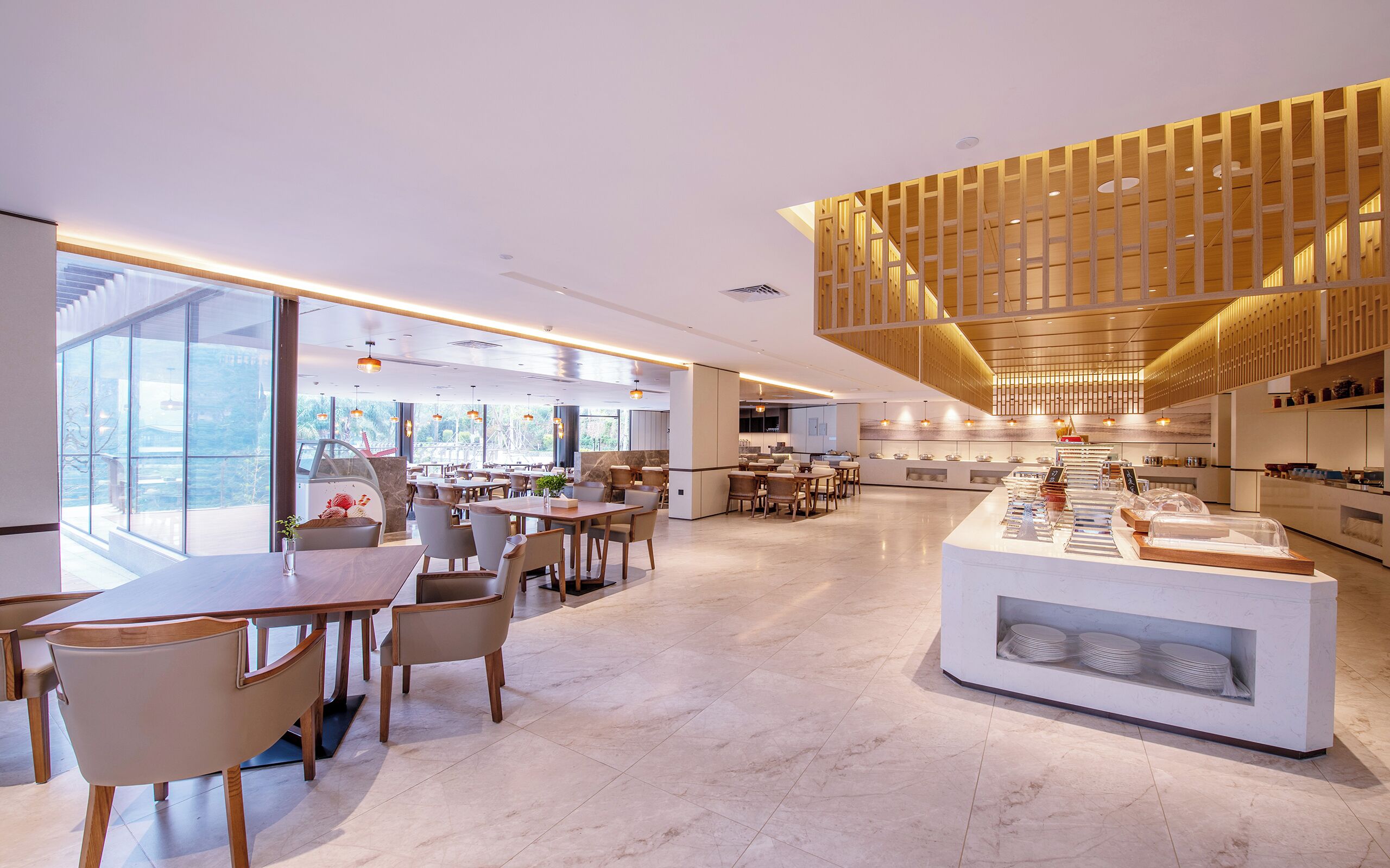 Un interior de restaurante moderno con un mostrador central de servicio, mesas y sillas para comer.
