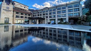 A hotel with a reflective pool, multiple floors, and a modern architectural design. - Fuzhou Royal Hot Spring Hotel & Resort (Fuzhou)