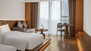 A hotel room with a large bed, a sofa, a small round table, and a chair. - Fuzhou Royal Hot Spring Hotel & Resort (Fuzhou)