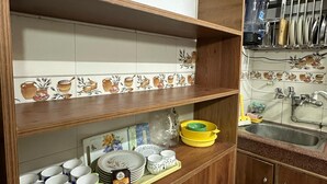 Une cuisine avec des meubles en bois, un pare-feu en carrelage et divers ustensiles de cuisine.