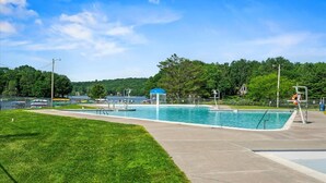 A swimming pool with a blue canopy, surrounded by a grassy area and trees. - Sleeps 13 • Private Sauna • Hot Tub • Game Room (Pocono Lake)