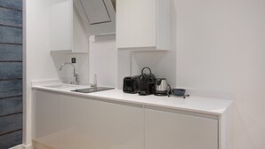 A modern kitchen with white cabinetry, a built-in sink, and a coffee maker. - Superb & New Apartment Saint Germain des Près (Paris)
