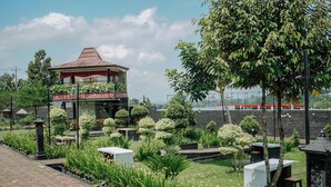 A garden with a gazebo, potted plants, and a brick pathway. - The Kotenang (Wonosobo)