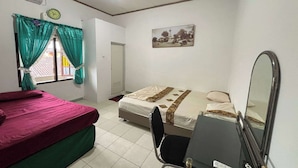 Une chambre avec deux lits, un bureau, une chaise, un miroir et une horloge au mur.