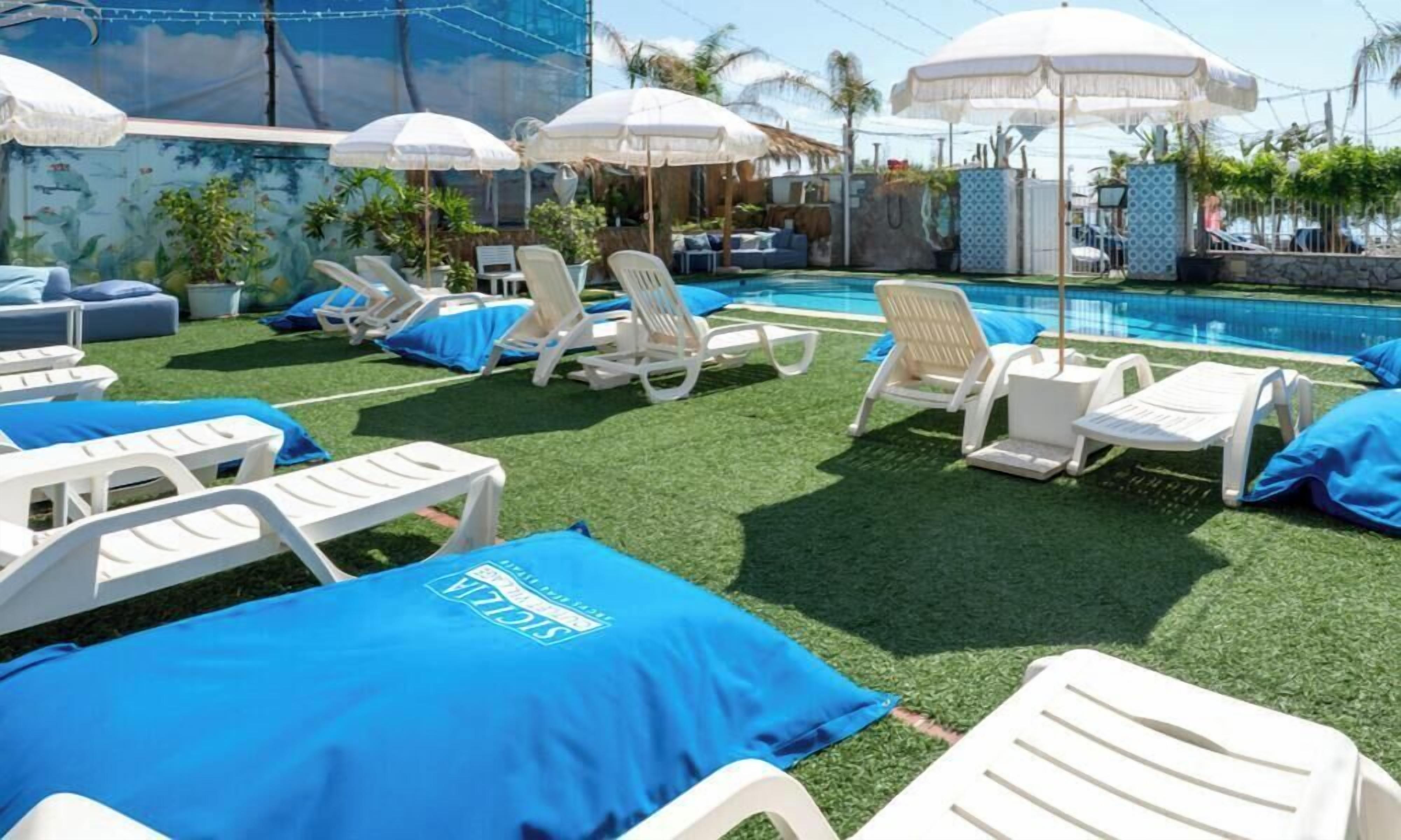 Una piscina al aire libre de temporada, sombrillas