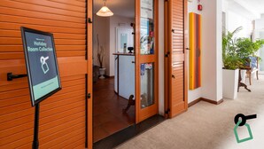 Zona de recepción de un hotel con un mostrador, un cartel de Holiday Room Collection y una puerta que da a la recepción.
