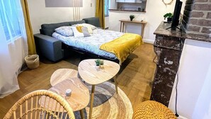 Ein kleines Schlafzimmer mit einem Bett, einem Schreibtisch, einem Sessel und einer Couch.