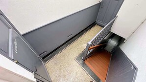 Eine enge Treppe mit Handlauf, die zu einer Tür mit Fenster führt.