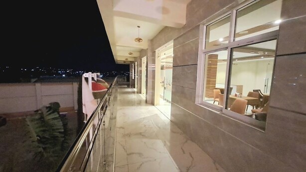 A corridor with a marble floor and glass doors leading to a dining area. - Abuya Palace Hotel Moyale (Moyale)