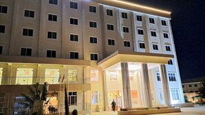 A multi-story hotel with a modern design, featuring a prominent entrance with large glass doors and a central column. - Abuya Palace Hotel Moyale (Moyale)