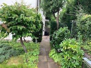 A stone pathway leading through a lush garden with various shrubs and trees. - Apartment 'Ruhige Im Schwarzwald' with Private Terrace and Wi-Fi (Pforzheim)