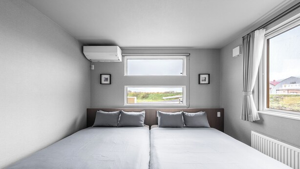Habitación doble con dos camas, ventana y vista al exterior.
