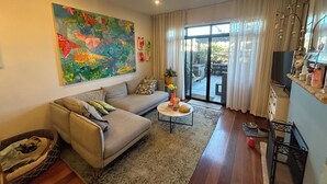 Un salon moderne avec un canapé, une table basse et un grand tableau abstrait accroché au mur.