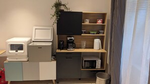 A compact kitchenette with a refrigerator, microwave, coffee maker, and a small trash bin. - Chez steph (Le Puy-en-Velay)