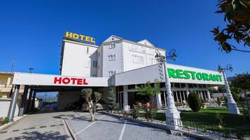 Hotel y restaurante con entrada accesible, paseo empedrado y zona exterior bien cuidada.