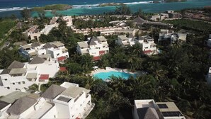 A resort with multiple buildings, a swimming pool, and a view of the ocean. - Tranquil Villa Apartment in Papa Remo Village-2326 (Watamu)