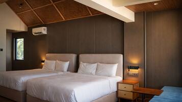 A modern hotel room with two beds, a wooden ceiling, and a small table.