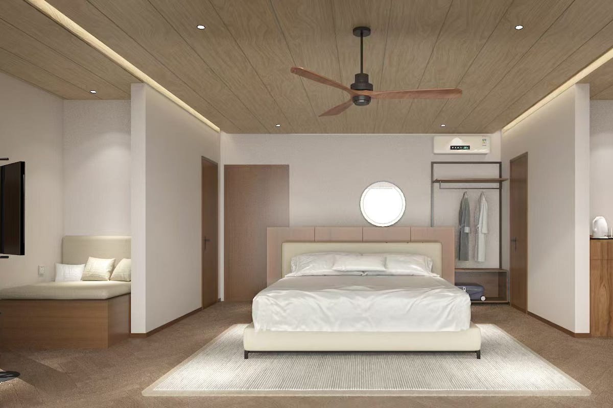 A modern bedroom with a large bed, a ceiling fan, a wardrobe, and a bedside table.