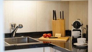 A modern kitchen with a sink, a coffee machine, and a cutting board with tomatoes. - North Sea - Modern and central 2-room apartment with balcony, WLAN. Pets (Sylt)