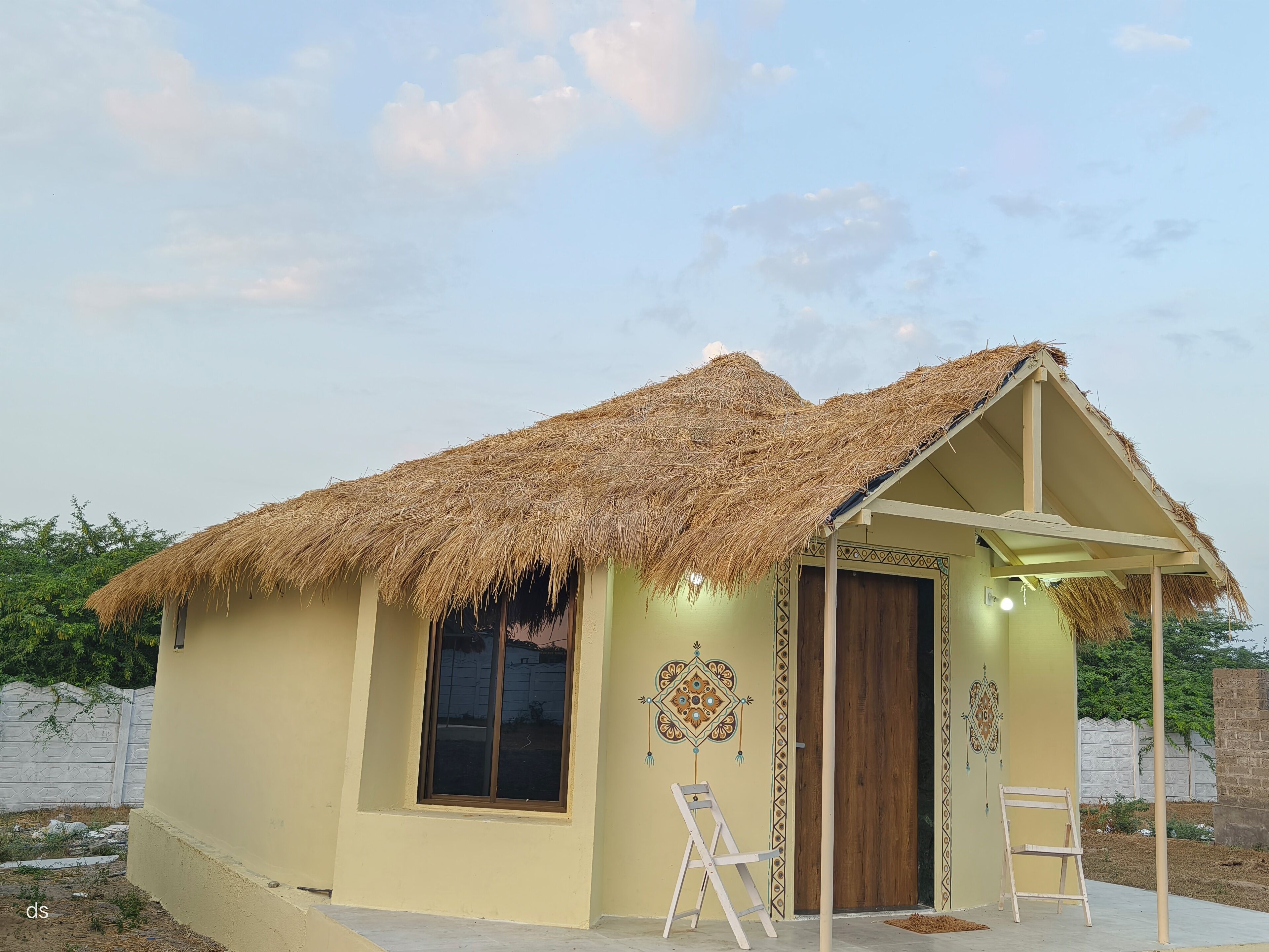 A small, single-story building with a thatched roof and a single door.