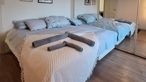 A bedroom with a large bed, a mirror, and framed artwork on the wall. - Waterfront Broadwater Master Bedroom Views Mirrors with own private beach front (Surfers Paradise)