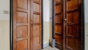 En hall med trädörrar, en papperskorg och en ljusströmbrytare på väggen.