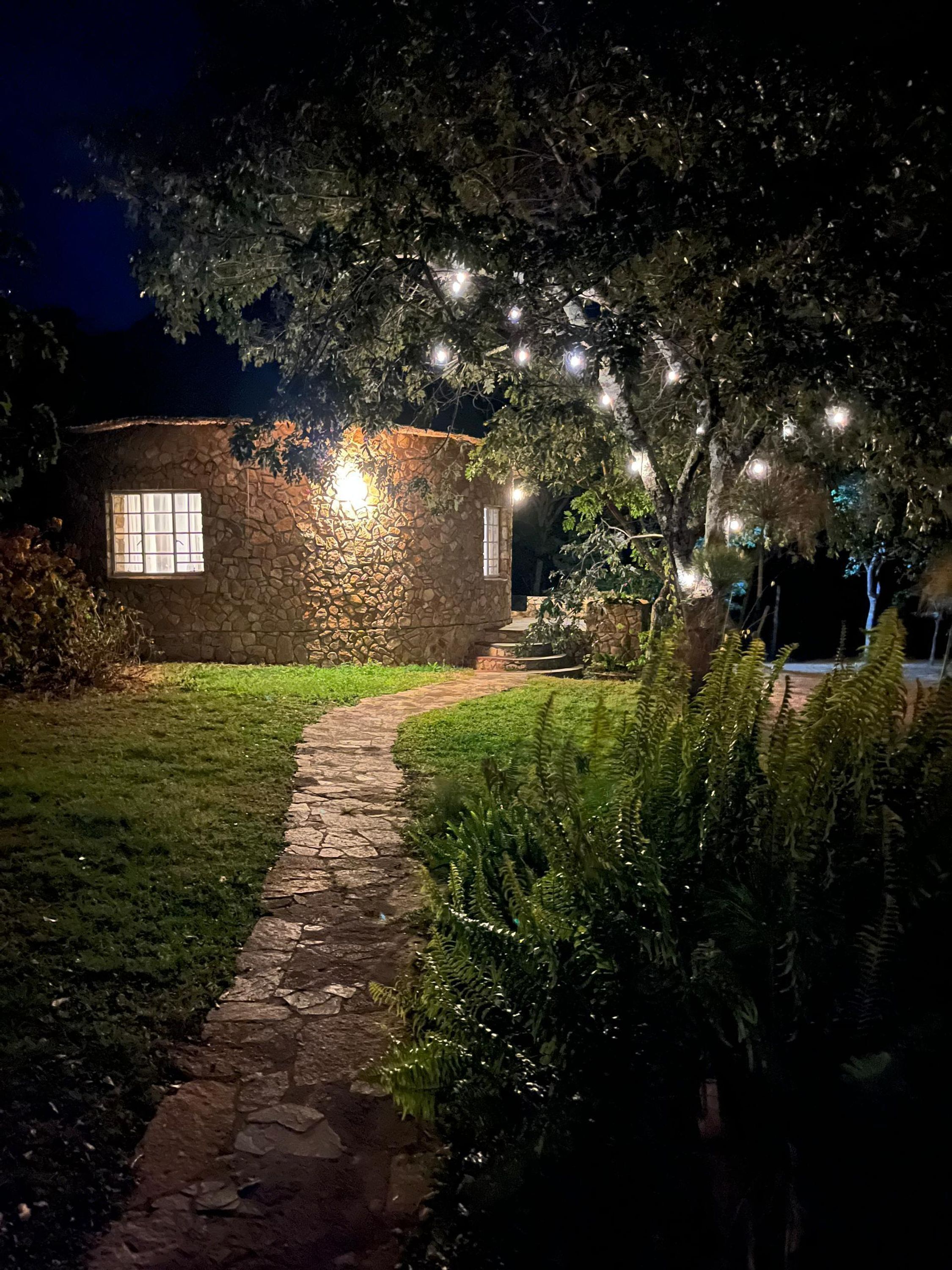 A stone building with a window and a stone pathway leading to it.