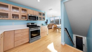 Una cocina moderna con armarios de madera, estufa de acero inoxidable y microondas.