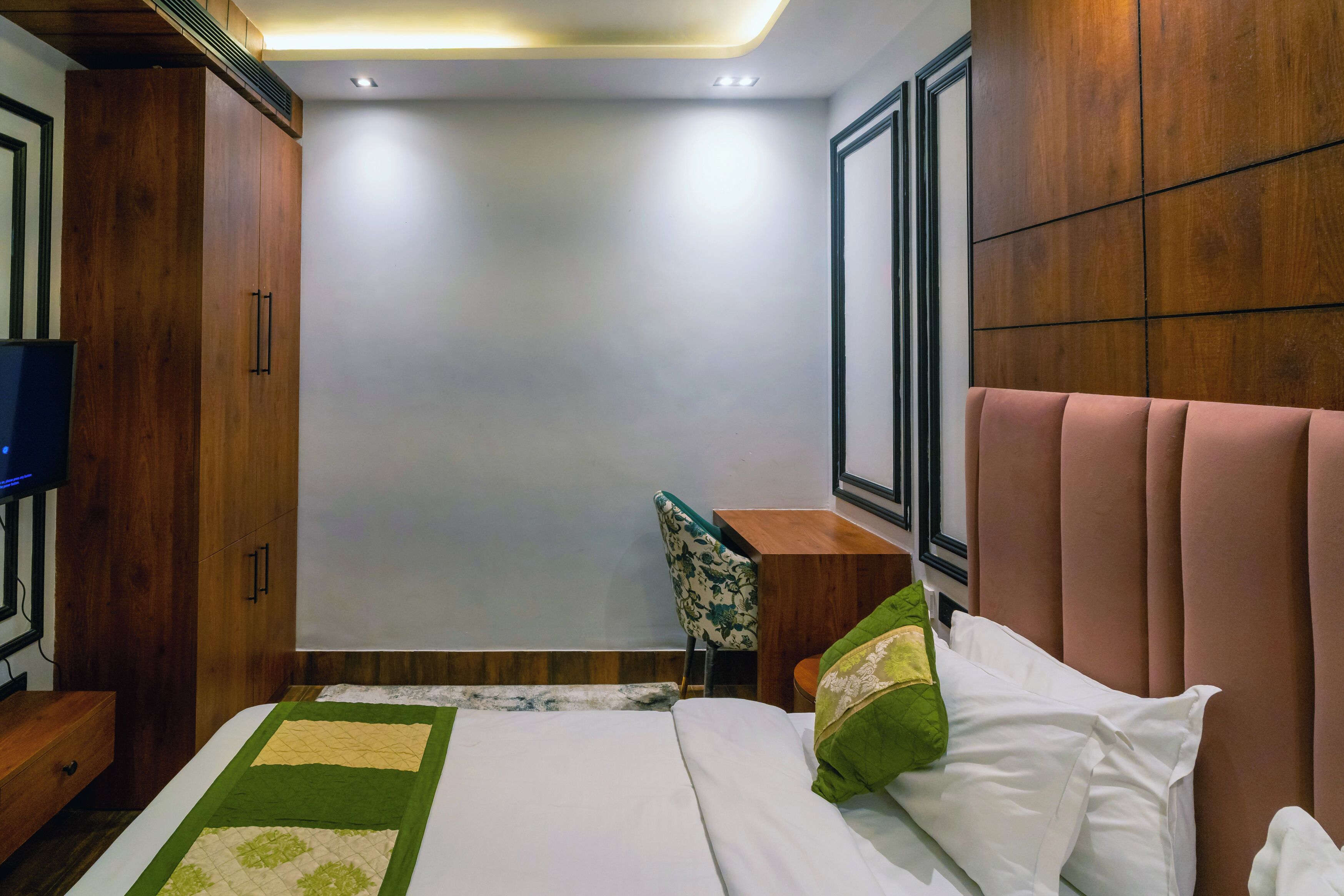 A bedroom with a bed, a desk, and a chair.