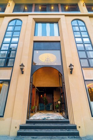 A building with a large arched entrance, two side windows, and a balcony with railings. - Hotel Sky Inn (Lucknow)
