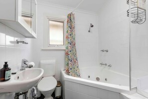 A bathroom with a white sink, toilet, and bathtub. - Golden Key by the Sea | Coastal Nostalgia in Henley Beach (Henley Beach)